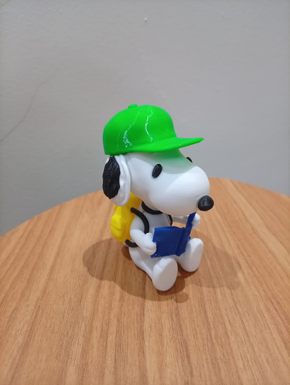 Figura decorativa do Snoopy vista em ângulo, com mochila amarela